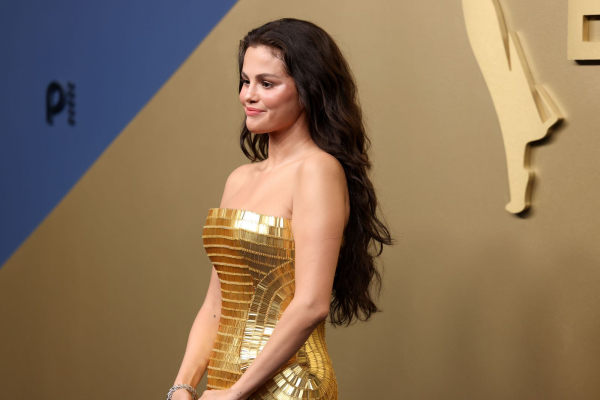 Selena Gomez attends the Emmy Awards in a gold dress and long waves.