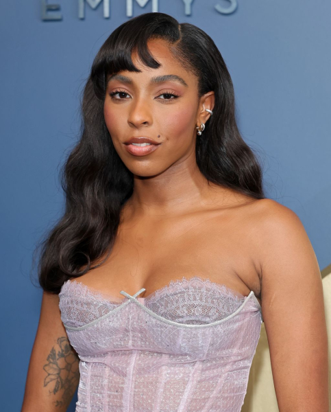 Jessica Williams posing in a lavender strapless dress